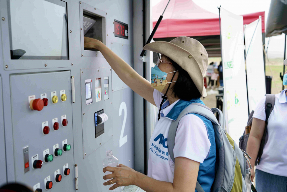 志工們將拾起的寶特瓶投入「好歸塑專車」，讓廢棄塑料空瓶可以直接粉碎、縮小體積，未來將可再製成購物袋、寶特衣、悠遊卡等生活用品